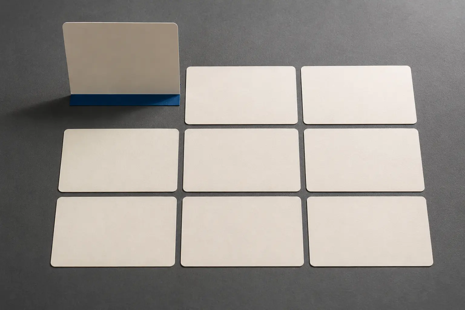 Nine real blank flashcards in a precise grid with one card standing on a cobalt hinge